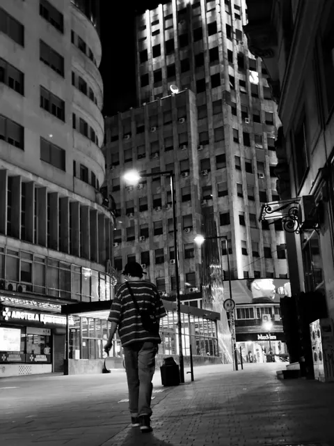 A man walking down an empty street at night